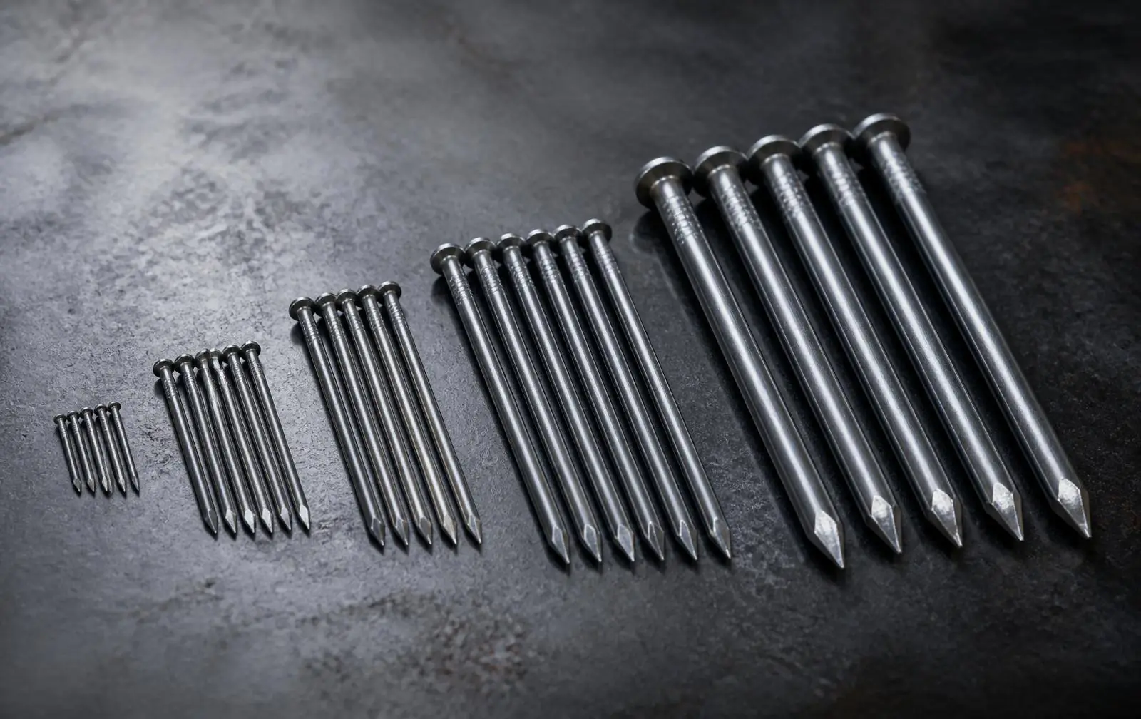 Steel wire nails of assorted sizes arranged in rows